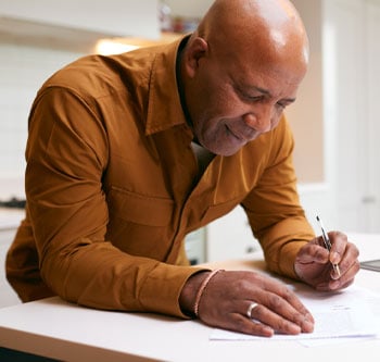 Man in orange shirt filling out paperwork
