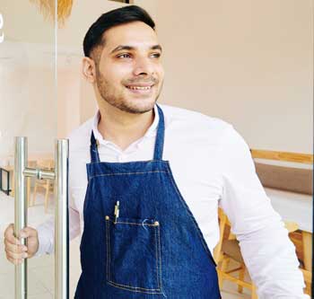 Man in blue apron smiling